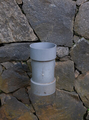 Naklejka premium sewer pipe close-up with the stone embankment in the background
