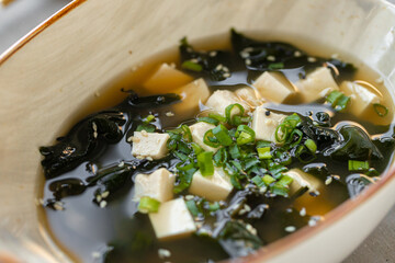 Japanese miso soup in a white bowl on the table