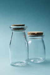 A glass jar with a stopper on a blue background. A jar for cosmetics or water, a place for text.