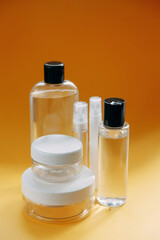 A set of eco-friendly natural cosmetics on a yellow background. Glass transparent bottles, a beautiful composition with an empty space for the text.