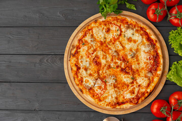 Tasty pizza on black wooden background top view