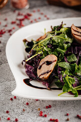 Fresh chicken salad with greens and sauce on decorated table