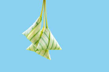 Glutinous rice wrapped with leaves on blue background. Also known as Ketupat Palas. Served during eid festival by Muslim.