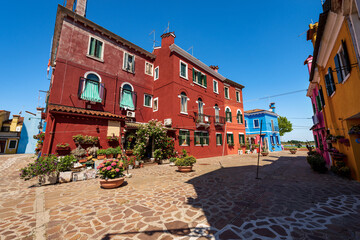 Fototapeta na wymiar Old houses with bright colors (multi colored ) in Burano island in a sunny spring day with clear sky. Venetian lagoon, Venice, UNESCO world heritage site, Veneto, Italy, southern Europe.