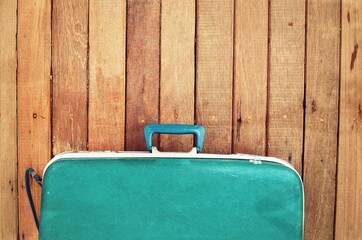 blue suitcase on a wooden background