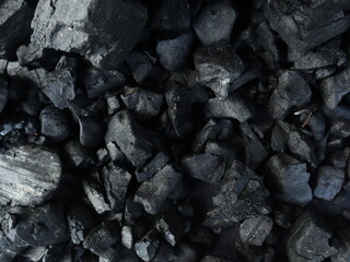 Dark coal texture, the remnants of wood burning into charcoal that can be used for barbecue