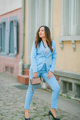 Portrait of a beautiful young woman in a blue suit with a bouquet of tulips. Spring.