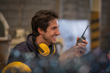 Industry  worker wearing safety uniform ,used radio communication, computer notebook on table  for...