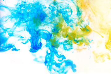 Fototapeta na wymiar Bright blue and yellow acrylic paint swirling in water. Ink moving in liquid creating abstract clouds. Traces of colorful dissolving in water, changing shape. Abstract decorative creative background.