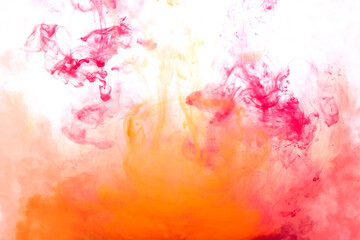 Bright pink and yellow acrylic paint swirling in water. Ink moving in liquid creating abstract clouds. Traces of colorful dissolving in water, changing shape. Abstract decorative creative background.