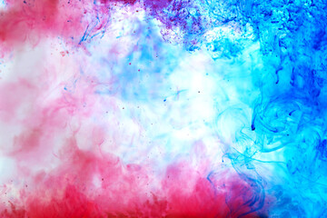 Beautiful ink mix macro. Blue, red, white colors watercolor are pouring. Paint movement macro. Fluid art painting. Moving flowing stream of liquid paint. Decorative abstract gradient background.