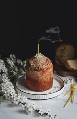 panettone with an extinguished candle on a table with a flowering branch