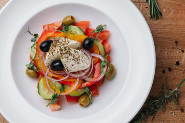 Close up of Greek salad with fresh vegetables, feta cheese and olives in a plate. Vegetarian healthy food diet