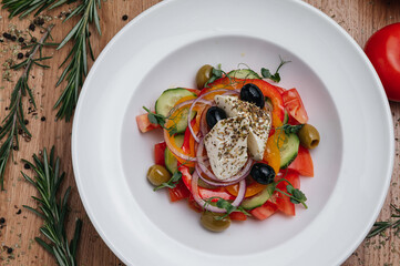 Close up of Greek salad with fresh vegetables, feta cheese and olives in a plate. Vegetarian healthy food diet