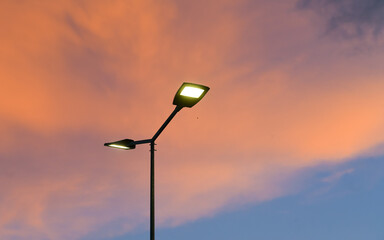Public street lighting pole with LED lights with an amazing sunset color background.