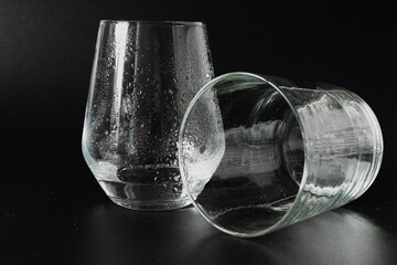 a glass with water and an empty glass