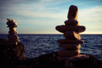 Zen stones on a ocean sea cliff in sunset sunrise time.