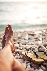 Man sunbathing on a rocky sea ocean beach.