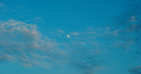 Evening blue sky with moon and colorful clouds