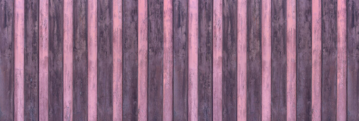 Alte Panorama Holzwand aus vertikalen Brettern abwechselnd gestrichen in lila und rosa