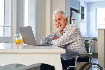 Senior in a wheelchair at the laptop waiting for a video call