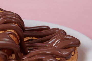 fresh pancake in a plate poured with chocolate paste, cream on buns, pancakes with chocolate