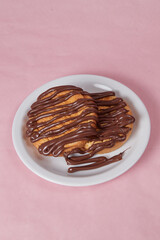 fresh pancake in a plate poured with chocolate paste, cream on buns, pancakes with chocolate
