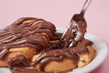 fresh pancake in a plate poured with chocolate paste, cream on buns, pancakes with chocolate