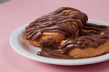 fresh pancake in a plate poured with chocolate paste, cream on buns, pancakes with chocolate