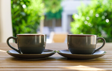 Two cups of hot coffee on wooden table close up.