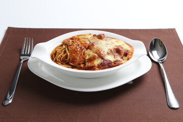 oven baked creamy cheese tomato Bolognese pasta with grilled chicken chop in bowl western chef cuisine seafood menu in white and brown background