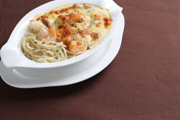 oven baked creamy cheese cabonala pasta with fresh big prawn in bowl western chef cuisine seafood menu in white and brown background