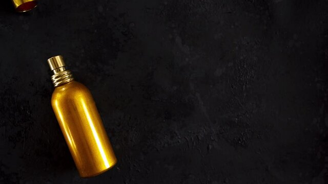Looped stop motion animation with Golden aroma perfume spray bottle and natural lily flowers on dark background with copy space. skincare lotus perfumed fragrance, aromatic cosmetic product