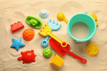Beach toy kit on sand, flat lay. Outdoor play