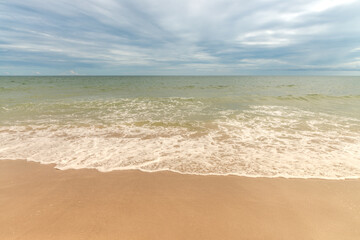 Fototapeta na wymiar Small waves on sandy beach on Atlantic ocean