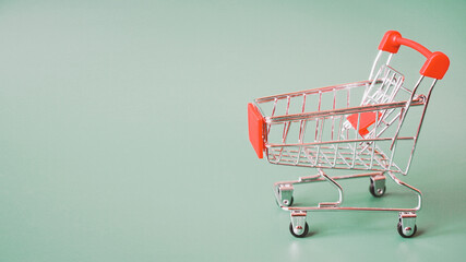 empty red shopping cart on dark green background with copy space