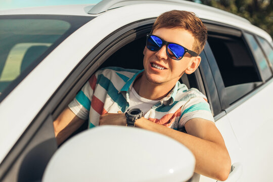 Rear View Of A Young Handsome Man Looking Straight Away While Driving A Car, A Man In The Driver's Seat Of A Car