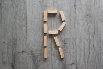 letter R natural wooden blocks on floor alphabet lettering