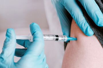 The doctor who gives the patient a vaccine, a vaccination against coronavirus infection. Medical...