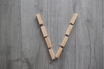 letter V natural wooden blocks on floor alphabet lettering