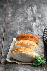 Three Chicken Tikka Empanadas on a rustic wooden table