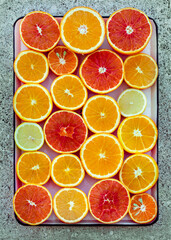 Oranges and lemons on light marble background.