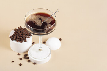 martini espresso cocktail in a glass on a beige background, space for text