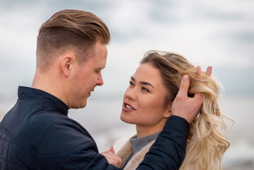 Two Young couple standing enjoying on a coast and enjoying each other.Summer,spring,autumn vacation.Closeup.