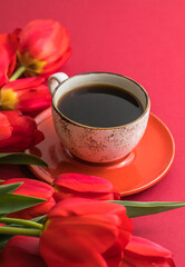 Bouquet of red  tulips and coffee cup arrangement with a lot of copy space for text. Spring mood concept. Greeting card for Birthday, Woman, Mother's Day, Wedding, Valentines day.