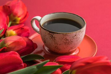 Bouquet of red  tulips and coffee cup arrangement with a lot of copy space for text. Spring mood concept. Greeting card for Birthday, Woman, Mother's Day, Wedding, Valentines day. v
