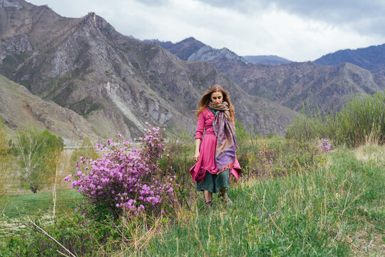 Beautiful woman wearing boho style dress standing in mountains