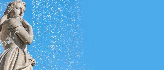 Banner with fountain statue of beautiful bathing woman at State Opera fountain in Vienna, Austria, at blue sky background with copy space.