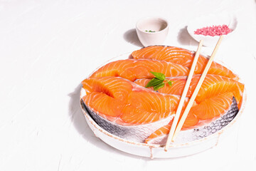 Fresh raw salmon or trout fish fillet steaks. Minimalistic design, modern hard light, dark shadow