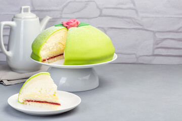 Traditional Swedish dessert Princess cake with green marzipan cover and pink rose decoration, on ...